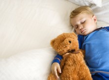 Child sleeping with bear.